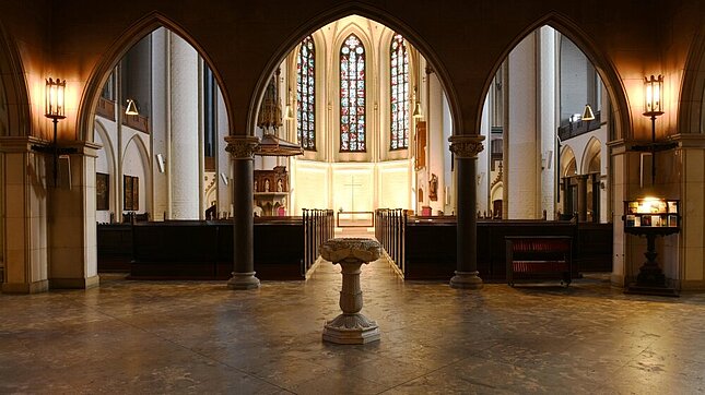 Die Innenansicht von St. Petri, wie diese sich beim Eintritt in den Kirchraum zeigt: Im Vordergund das Taufbecken, hinten der Altarraum